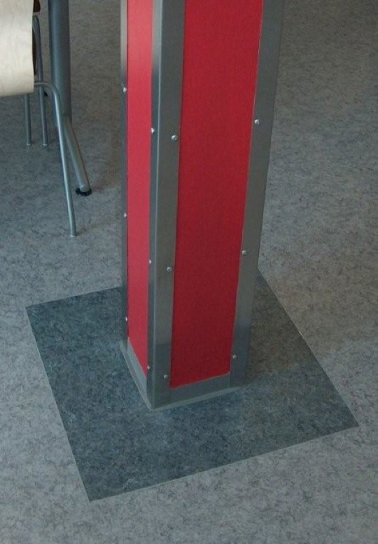 Bright red column with metal corners on top of a tile of different color from the rest of the floor