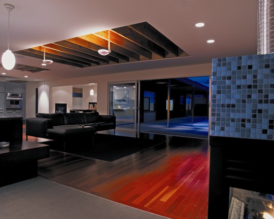 Diagonal view of both living room and kitchen shows hardwood floor as sliding glass doors to outside