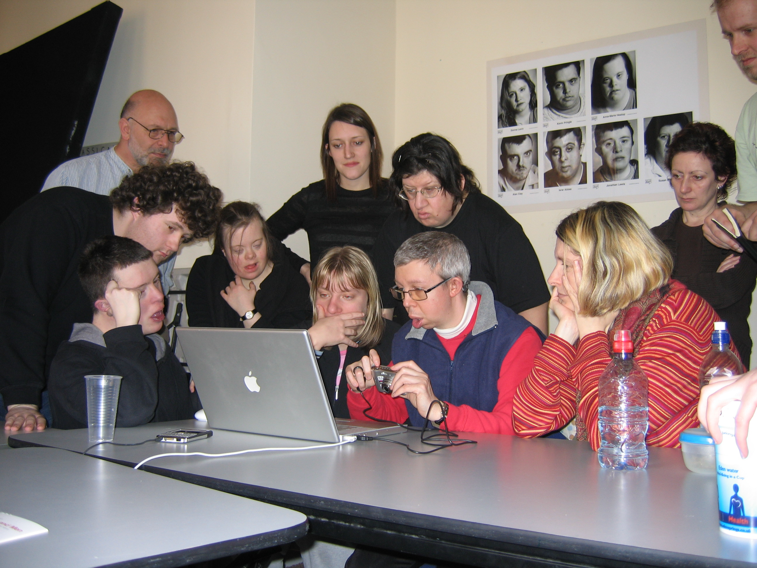 Group of users with various abilities gathered around laptop testing equipment