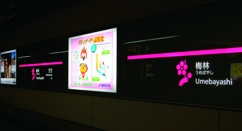 Wall of subway with Umebayashi's pink color and flower-like symbol