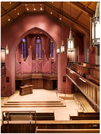 Chapel with dark pink walls and ornate organ behind the altar