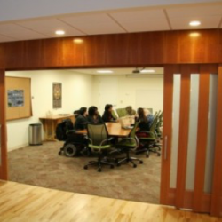 View into conference room with individuals seated around the conference table.