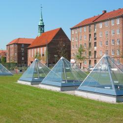 Glass prism pyramids in a grass lawn in front of historic brick buildings