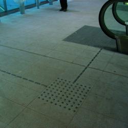 Dark tile floor with metal trncated domes in a square pattern