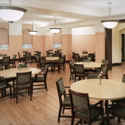 Several round tables surrounded by five chairs each in typical dining hall layout